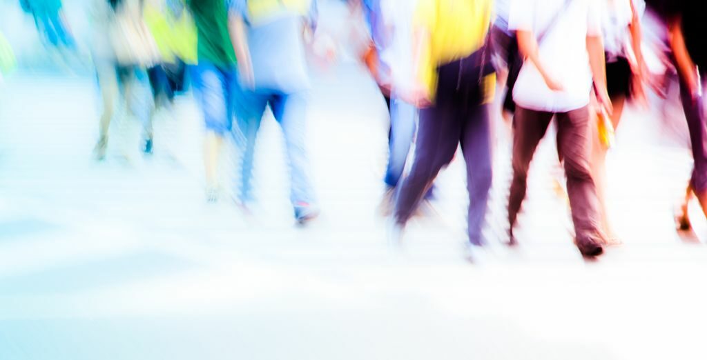 A crowd of blurred people's legs walking forward from the top left to bottom right.